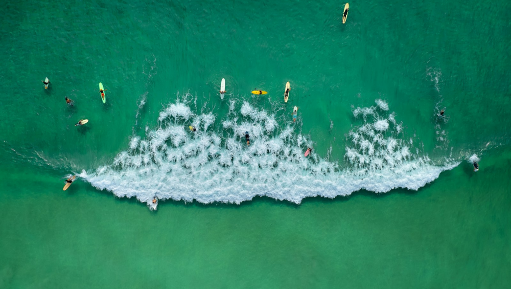 Surfers ride a large wave in the ocean