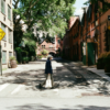 Person walks down a street with "dead end" signs.